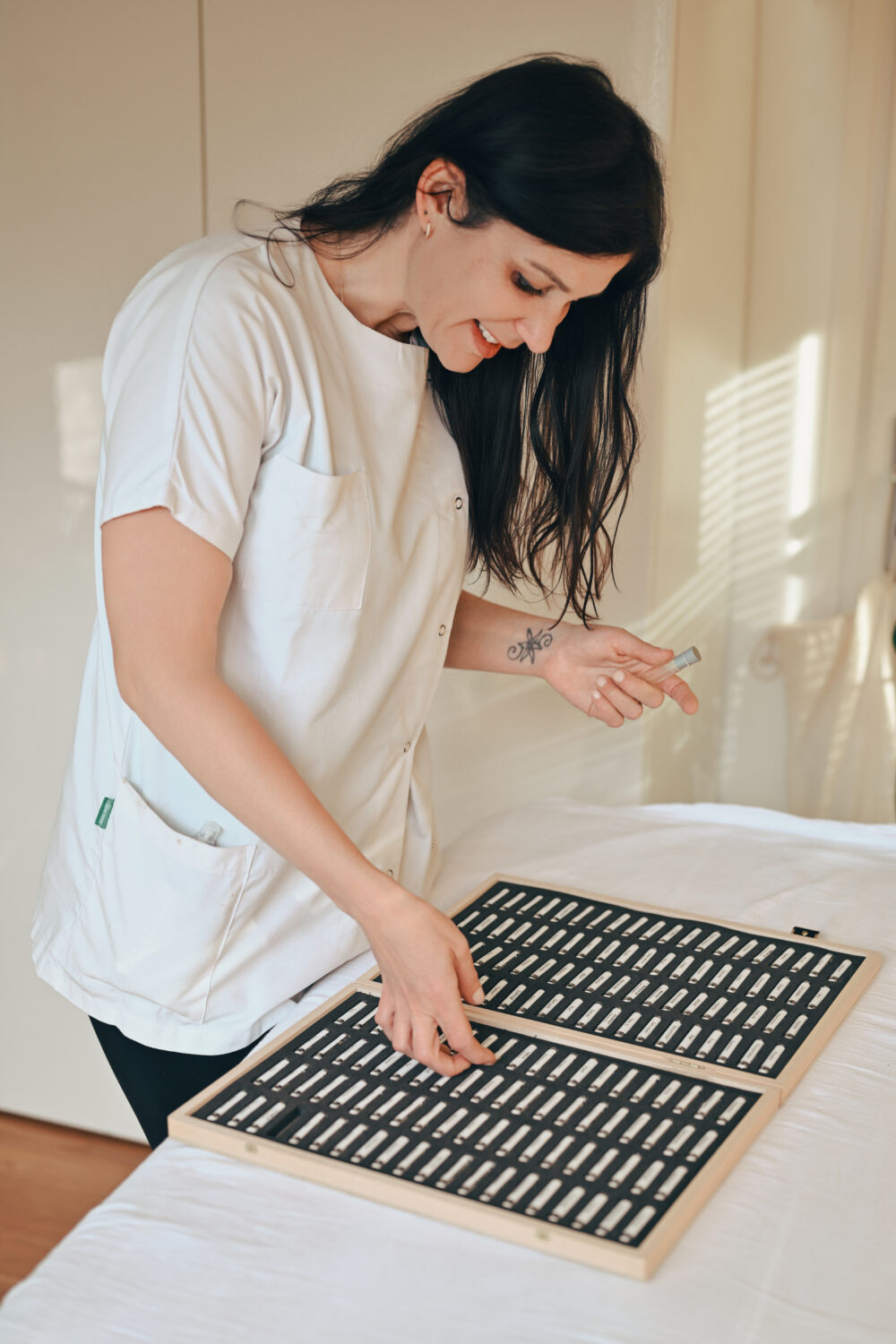 Céline Hubert tenant les fioles de Bye Bye Allergie dans son cabinet à Annecy